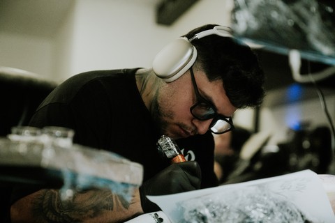 Sadone concentrating while tattooing in the studio.